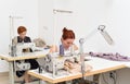 Two caucasian women seamstress at work on sewing machines in a sewing studio Royalty Free Stock Photo