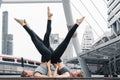 Two caucasian yoga partners having yoga workout outdoor in city