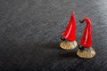 Two ceramic Christmas elves in red hats on a black background