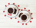 Two ceramic cups of coffee with red hearts on the wooden backgro Royalty Free Stock Photo