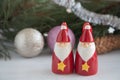 Two ceramic figures of Santa Clauses, Christmas decorations for the Christmas tree. New Year`s toys on a white wooden background Royalty Free Stock Photo