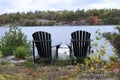 Two chairs in island. Autumn time in cottage. Lake, fall forest and cloudy sky