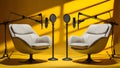 Two chairs and microphones in podcast or interview room isolated on solid yellow background Royalty Free Stock Photo