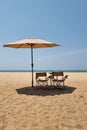 Two chairs sit nestled under a colorful umbrella on a serene sandy beach, inviting relaxation and enjoying the scenic Royalty Free Stock Photo