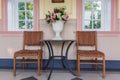 Two chairs and table with bouquet of flowers in vase on a patio Royalty Free Stock Photo
