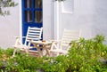 Two chairs and a table near a white wall outdoors in Greece Royalty Free Stock Photo