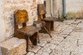 Two chairs and a table on the stone pavement of the city street. Handmade from old wood. Antique styling Royalty Free Stock Photo