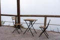 Two chairs and a table on a terrasse in the fog, vesuv mountain, italy Royalty Free Stock Photo