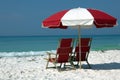 Two chairs and umbrella on white sand beach