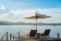 Two chairs and umbrella on wooden desk against blue sky Royalty Free Stock Photo