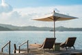 Two chairs and umbrella on wooden desk against blue sky Royalty Free Stock Photo