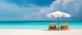 Two chairs under umbrella in tropical beach