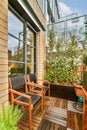 a porch with two wooden chairs and large windows Royalty Free Stock Photo