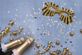 Two champagne bottles with carnival mask, confetti stars and party streamers on blue background. Christmas background, top view, Royalty Free Stock Photo