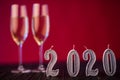 New Year decoration. Two gobelts with champagne with Christmas or New Year 2020 decoration on red light background Royalty Free Stock Photo