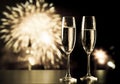 two champagne glasses against holiday lights and fireworks - new year celebration Royalty Free Stock Photo