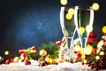 Two champagne glasses and christmas decoration over blue snow golden bokeh background. Happy New Year Celebration. Selective focus Royalty Free Stock Photo