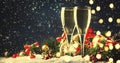 Two champagne glasses and christmas decoration over blue snow golden bokeh background. Happy New Year Celebration. Selective focus Royalty Free Stock Photo
