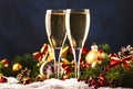 Two champagne glasses and christmas decoration over blue snow golden bokeh background. Happy New Year Celebration. Selective focus Royalty Free Stock Photo