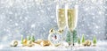 Two champagne glasses and christmas decoration over gray golden bokeh under the snow background. Happy New Year Celebration. Royalty Free Stock Photo