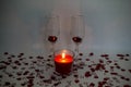 Two champagne glasses with a candle surrounded by heart shaped confetti