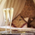 Two champagne glasses with oriental canopy bed at the background Royalty Free Stock Photo
