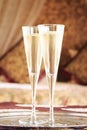 Two champagne glasses with oriental canopy bed at the background