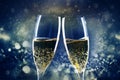 two champagne glasses ready to bring in the New Year - holiday lights and fireworks in the background Royalty Free Stock Photo