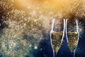 two champagne glasses ready to bring in the New Year - holiday lights and fireworks in the background Royalty Free Stock Photo