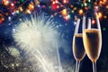 two champagne glasses ready to bring in the New Year - holiday lights and fireworks in the background Royalty Free Stock Photo