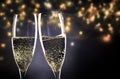 two champagne glasses ready to bring in the New Year - holiday lights and fireworks in the background Royalty Free Stock Photo