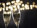 two champagne glasses ready to bring in the New Year - holiday lights and fireworks in the background Royalty Free Stock Photo