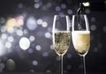 two champagne glasses ready to bring in the New Year - holiday lights and fireworks in the background Royalty Free Stock Photo