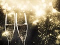 two champagne glasses ready to bring in the New Year - holiday lights and fireworks in the background Royalty Free Stock Photo