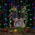 Two champagne glasses and a red alarm clock on a bokeh background. Royalty Free Stock Photo