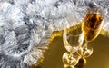 Two champagne or wine glasses with gold and silver christmas tinsel decoration. Royalty Free Stock Photo