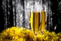 Two champagne or wine glasses with gold and silver christmas tinsel decoration. Royalty Free Stock Photo