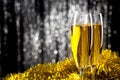 Two champagne or wine glasses with gold and silver christmas tinsel decoration. Royalty Free Stock Photo