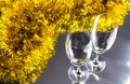 Two champagne or wine glasses with gold and silver christmas tinsel decoration. Royalty Free Stock Photo