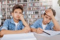 Two charming young twin brothers studying at the library together