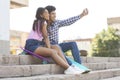 Two cheerful african teenagers taking selfie outdoors