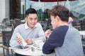 Two cheerful asian business people discussing with documents Royalty Free Stock Photo