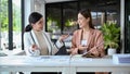 Two cheerful Asian businesswomen having a good conversation while working together Royalty Free Stock Photo