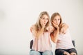 Two attrative sisters twins pointing over white background