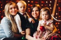 Two mothers sitting with cute kids christmas presents. Royalty Free Stock Photo