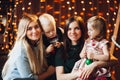 Two mothers sitting with cute kids christmas presents. Royalty Free Stock Photo