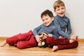 Two cheerful brother sitting next to each other to the floor Royalty Free Stock Photo