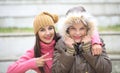 Two cheerful cute girls, one hugging her best female friend outdoors