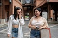 Two cheerful female friends are enjoying talking while walking around the city on a shopping day Royalty Free Stock Photo