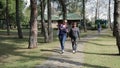 Two cheerful female friends walking in the park in the summer